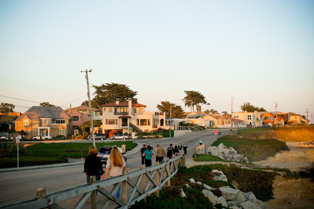 People standing at an overlook near the road on the coastline.